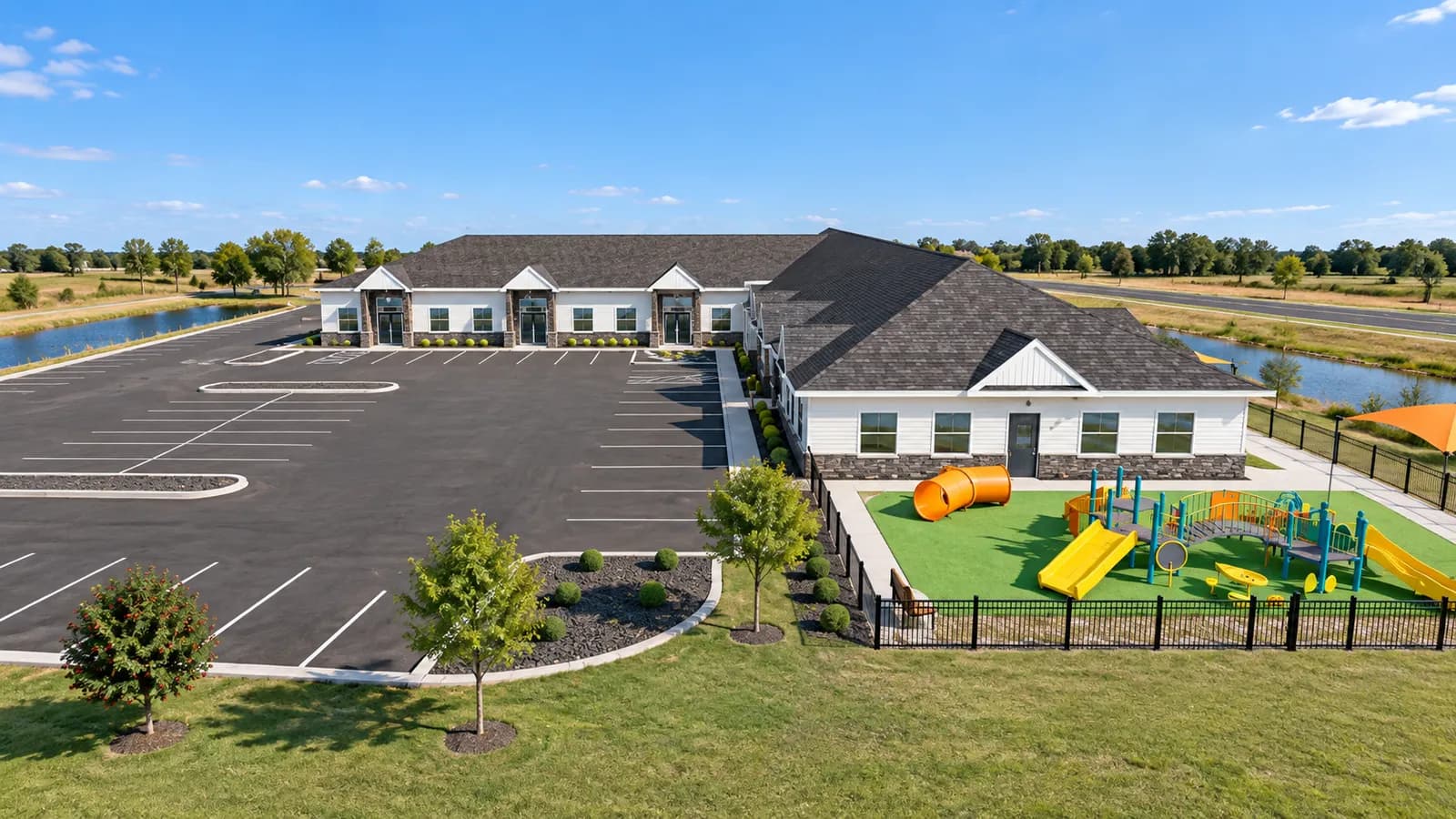 Aerial rendering of the fenced playground behind the East Bethel childcare center with play structures and shade sails