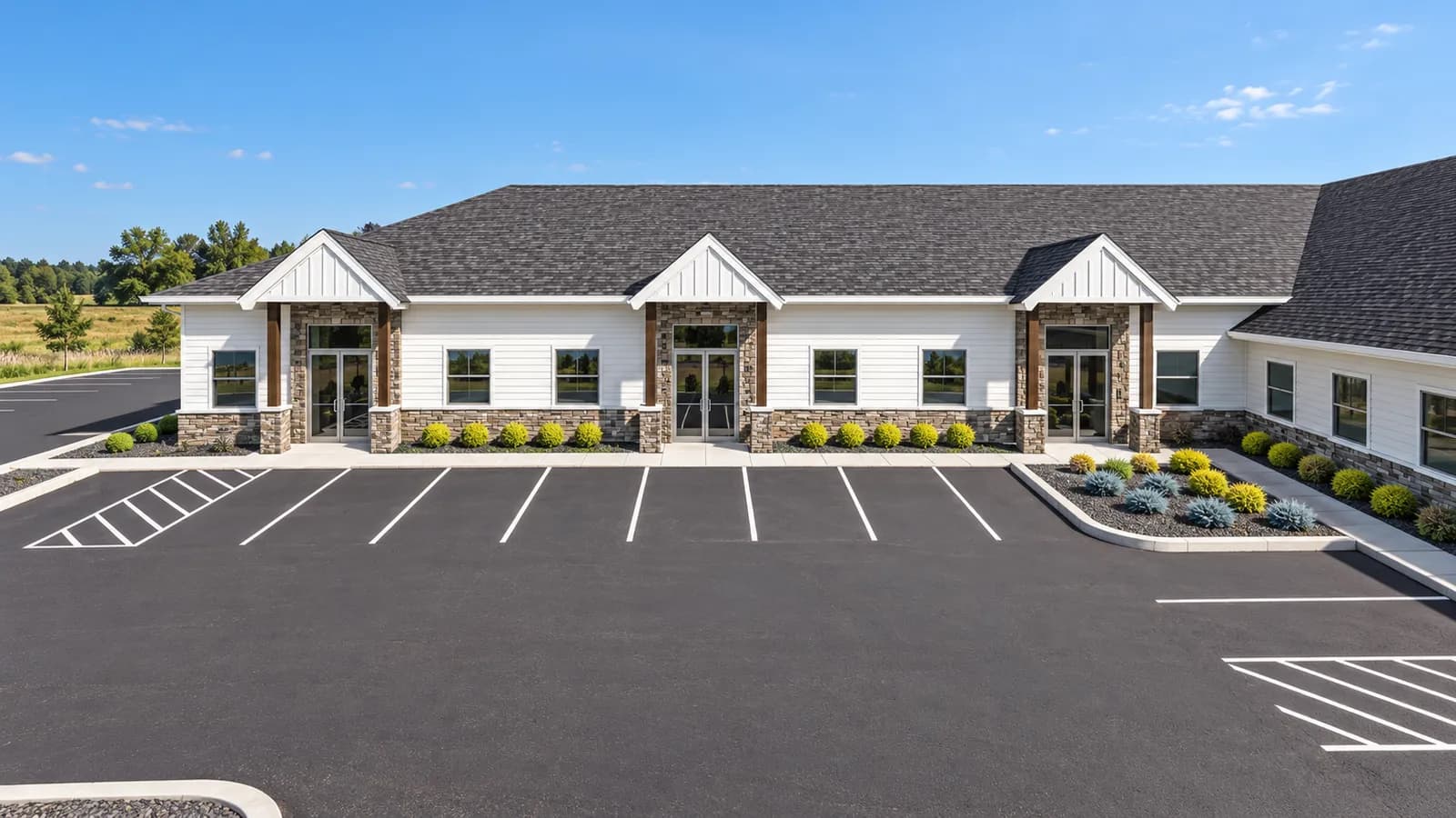 Front elevation rendering of a single-story childcare center with stone accents and gabled entries
