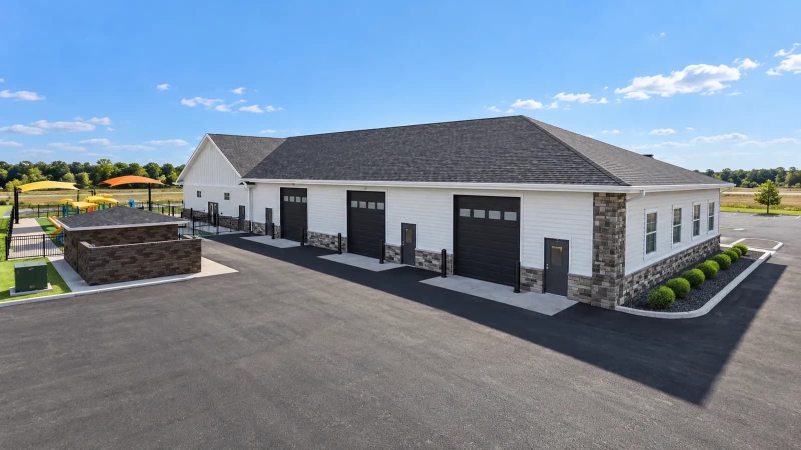 Rear elevation rendering of the childcare building showing garage doors and a stone corner